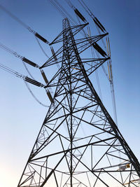 Low angle view of electricity pylon against clear sky