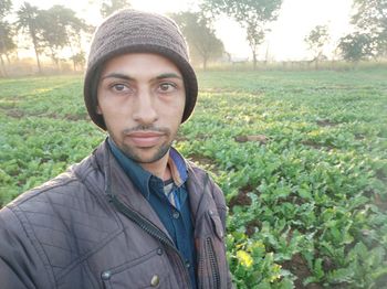Portrait of young man standing against plants
