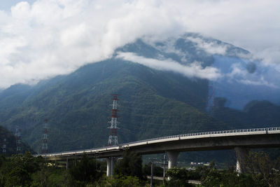 Scenic view of bridge over mountains against sky