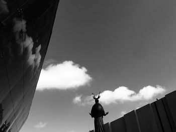 Low angle view of statue against buildings in city