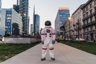 Full length portrait of person standing in city against buildings