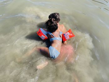 High angle view of boy and girl swimming in sea