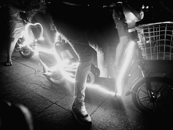 Low section of people standing on street at night