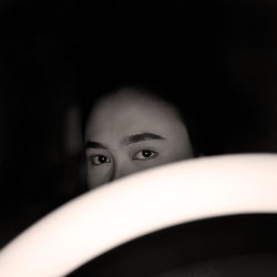 Close-up portrait of teenage girl in darkroom