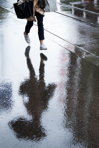 Low section of person walking on wet street