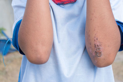 Midsection of child standing against blue wall