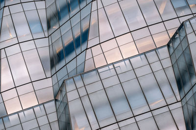 Low angle view of glass building against sky