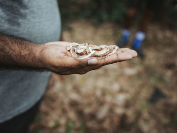 Midsection of man holding stick on land