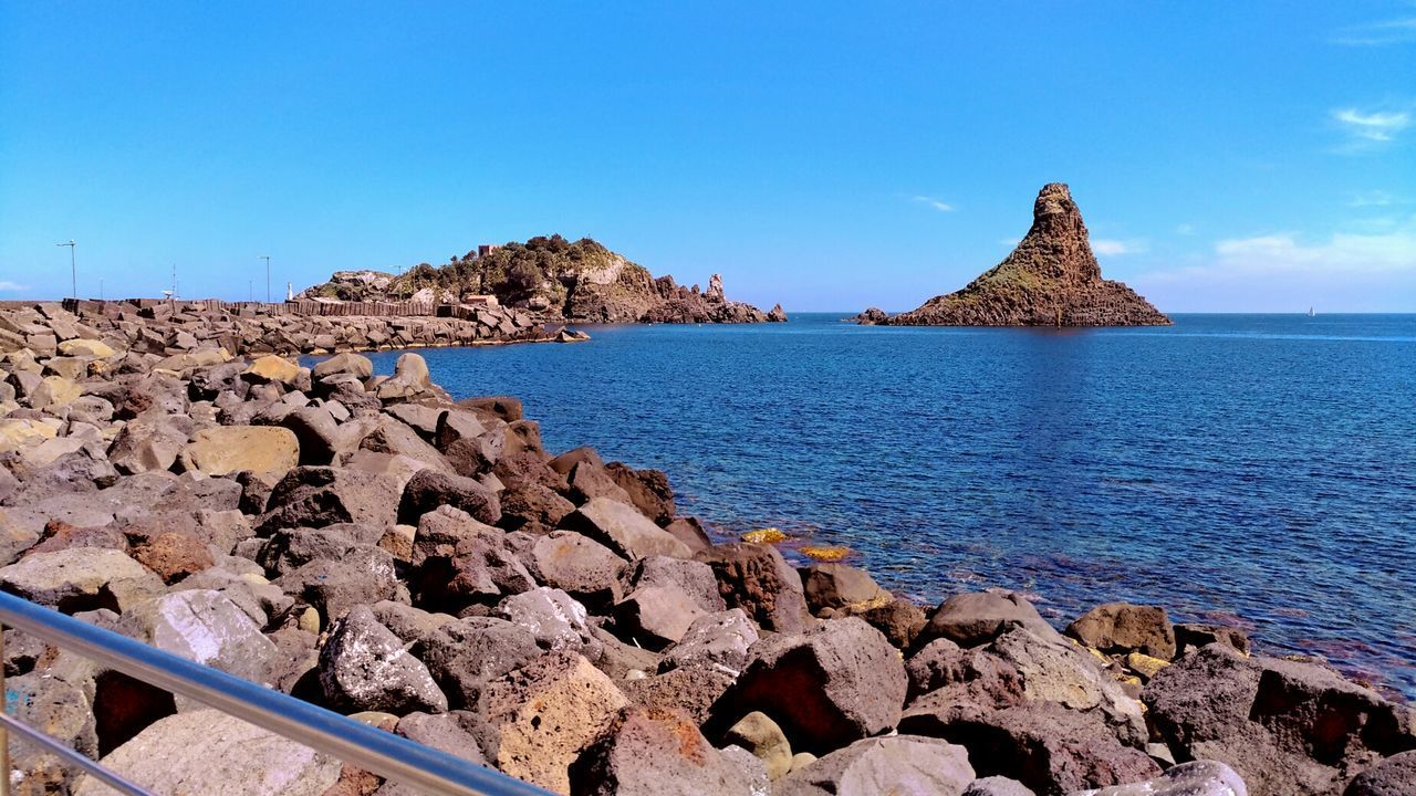 PANORAMIC VIEW OF SEA AND ROCKS AGAINST CLEAR BLUE SKY