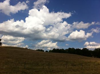 Scenic view of field against cloudy sky