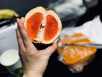 Cropped hand of person holding grapefruit