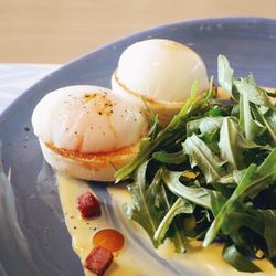 Close-up of eggs benedict and arugula in plate