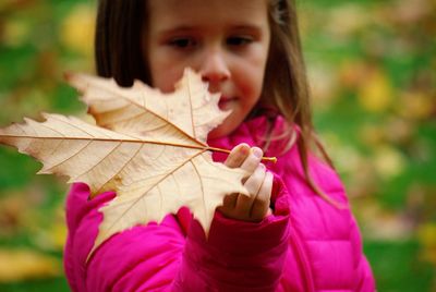 Close-up of girl holding maple leaf