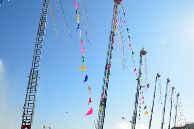 Low angle view of multi colored umbrellas hanging against sky