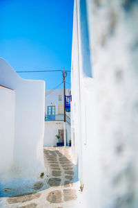 Buildings by sea against clear blue sky