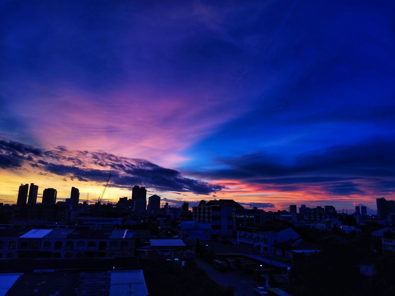 HIGH ANGLE VIEW OF CITY AGAINST DRAMATIC SKY