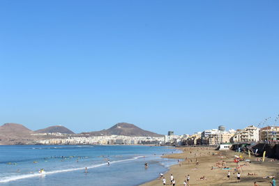 Scenic view of beach against clear blue sky