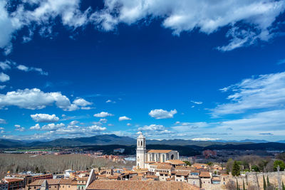 Houses in town against cloudy sky