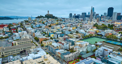 High angle view of cityscape by sea against sky