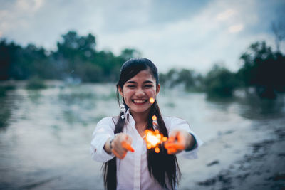 Portrait of smiling young woman standing outdoors