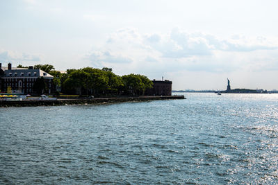 Scenic view of sea by buildings against sky