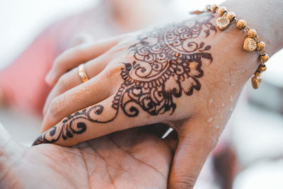 Cropped image of woman with henna tattoo on hand