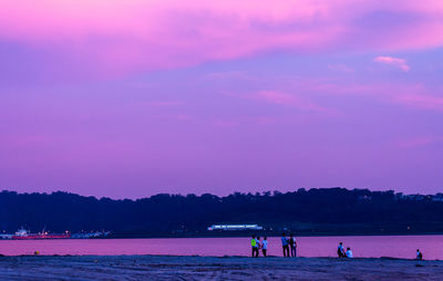 Silhouette of people overlooking calm sea