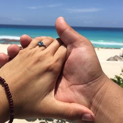 Close-up of cropped hand holding sea