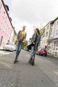 Young women riding electric scooters in the street
