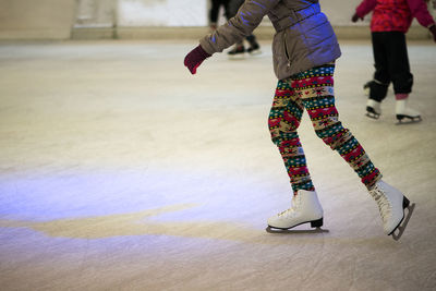 Low section of child skateboarding on ice rink