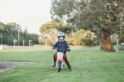 Young boy sitting on a motorbike in the park