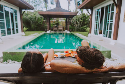 Rear view of woman relaxing on swimming pool