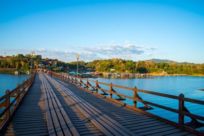 Pier over lake against blue sky