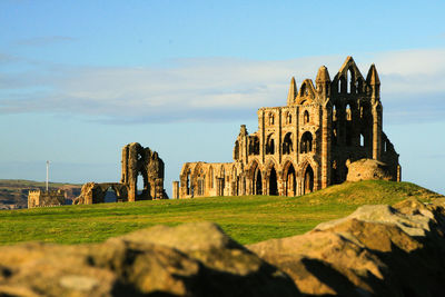 Scenic view of old structure against cloudy sky