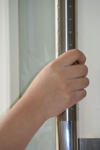 Close-up of hand holding glass door