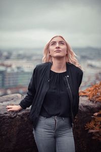 Portrait of young woman standing against sea