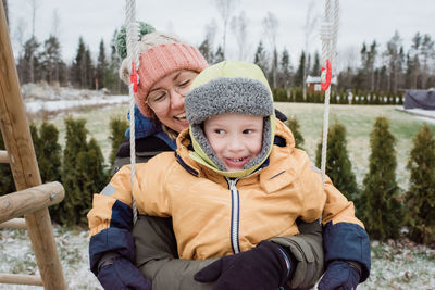 Mother and son laughing having fun playing outside in the snow