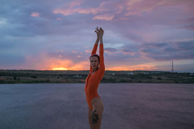 Full length of woman jumping against sky during sunset