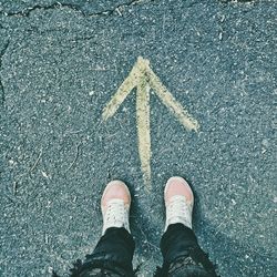 Low section of man standing on road