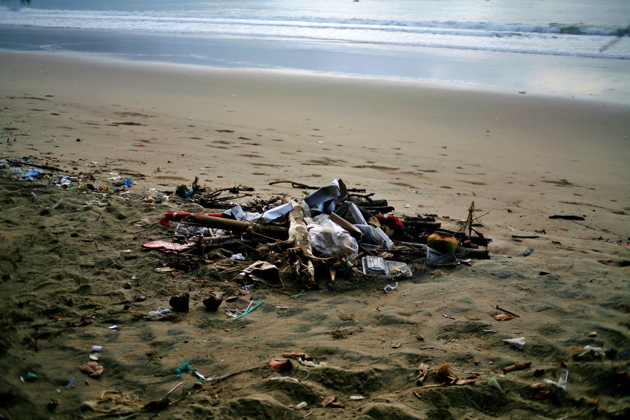 HIGH ANGLE VIEW OF GARBAGE ON SAND AT BEACH