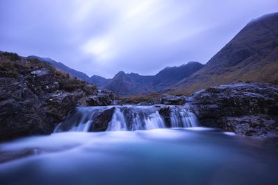Scenic view of waterfall against sky