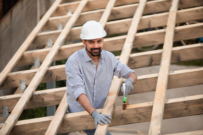 Full length portrait of young man standing at construction site