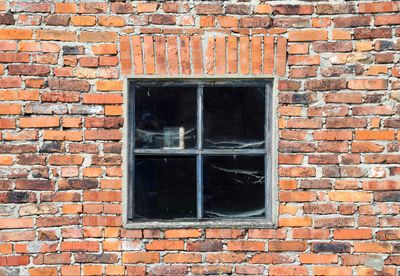 Low angle view of window on brick wall of building