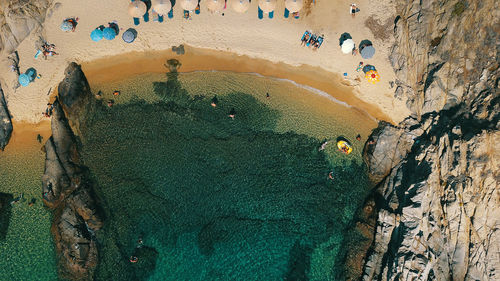 Aerial view of people on beach by rock formation