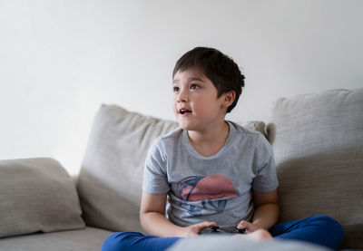 Portrait of boy sitting on sofa at home