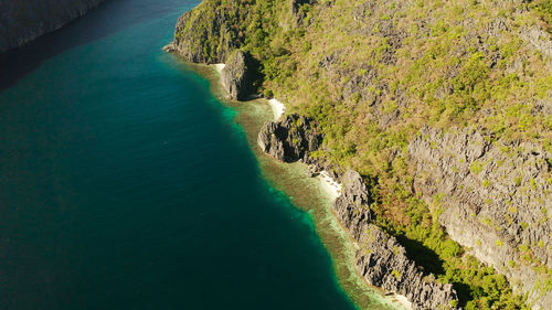 Tropical landscape bay with beach and clear blue water surrounded by cliffs. el nido, philippines