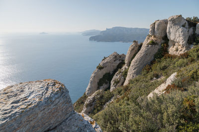 Rock formations by sea against sky