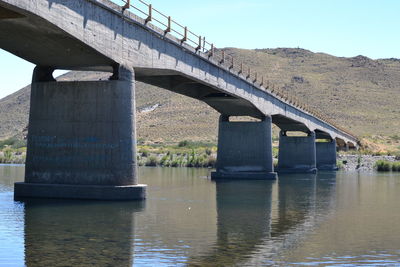 Low angle view of bridge over river against sky