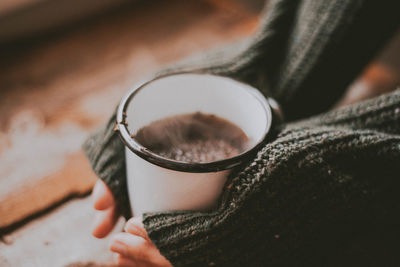 Cropped hands holding coffee cup during winter