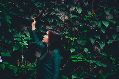 Woman holding tire hanging on plant